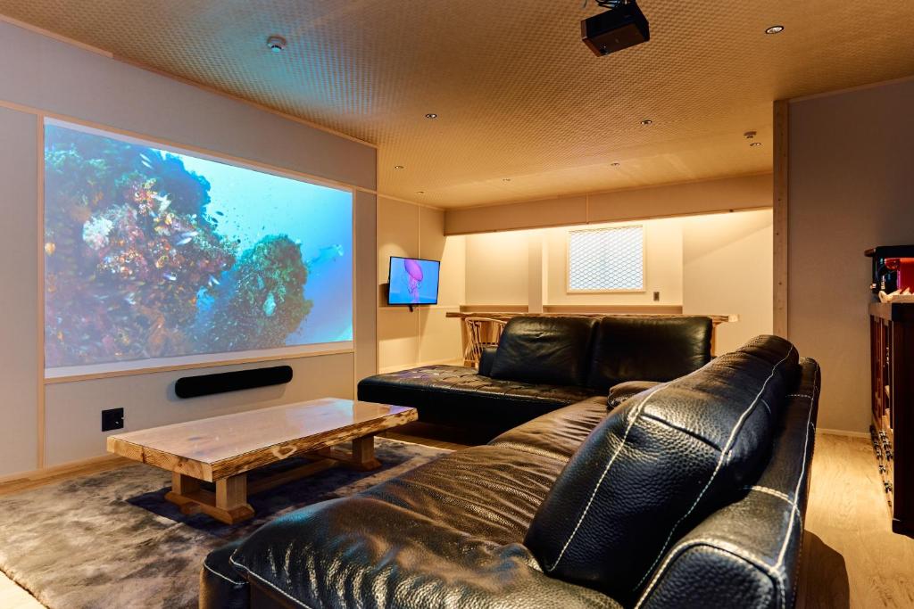 大阪Konjaku-So Tempozan Osaka Bay -Universal Bay Area-的客厅配有真皮沙发和大屏幕电视