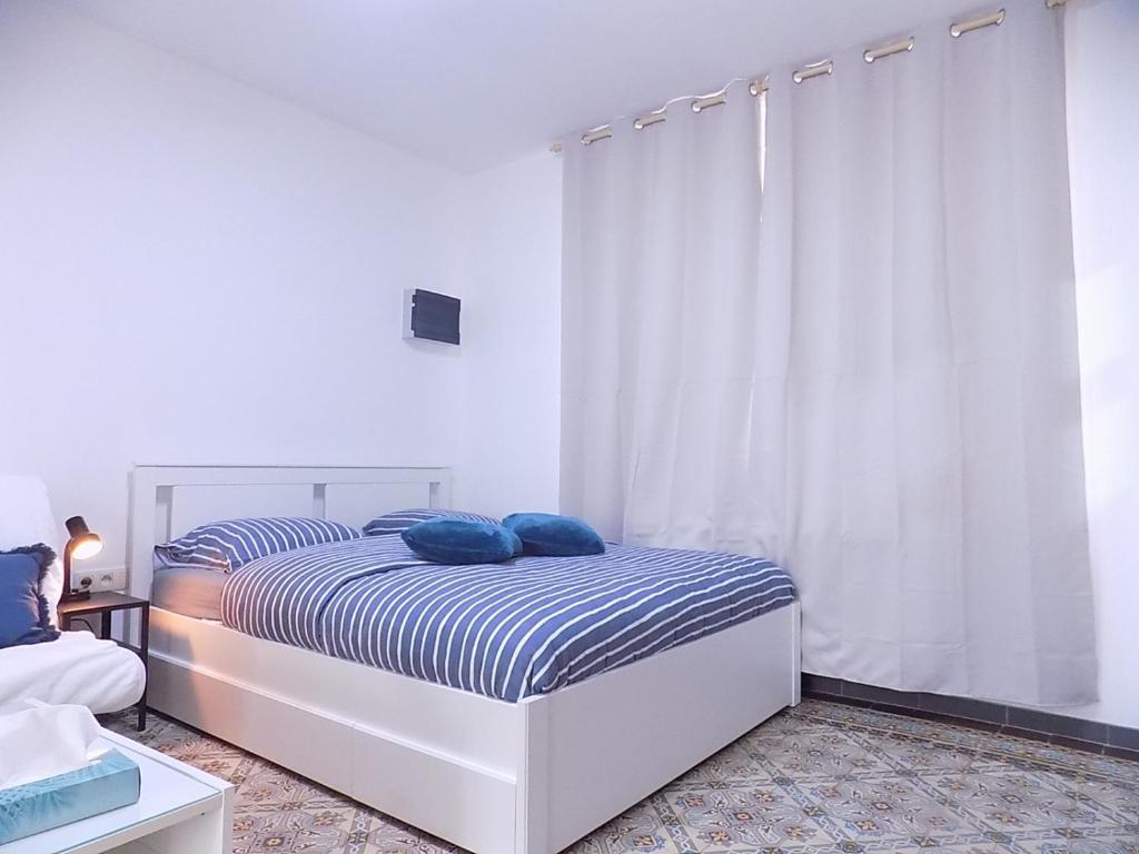 沙勒罗瓦Maison LYDIE - Meublé de vacances 3 étoiles的一间卧室配有一张带蓝色枕头的床。