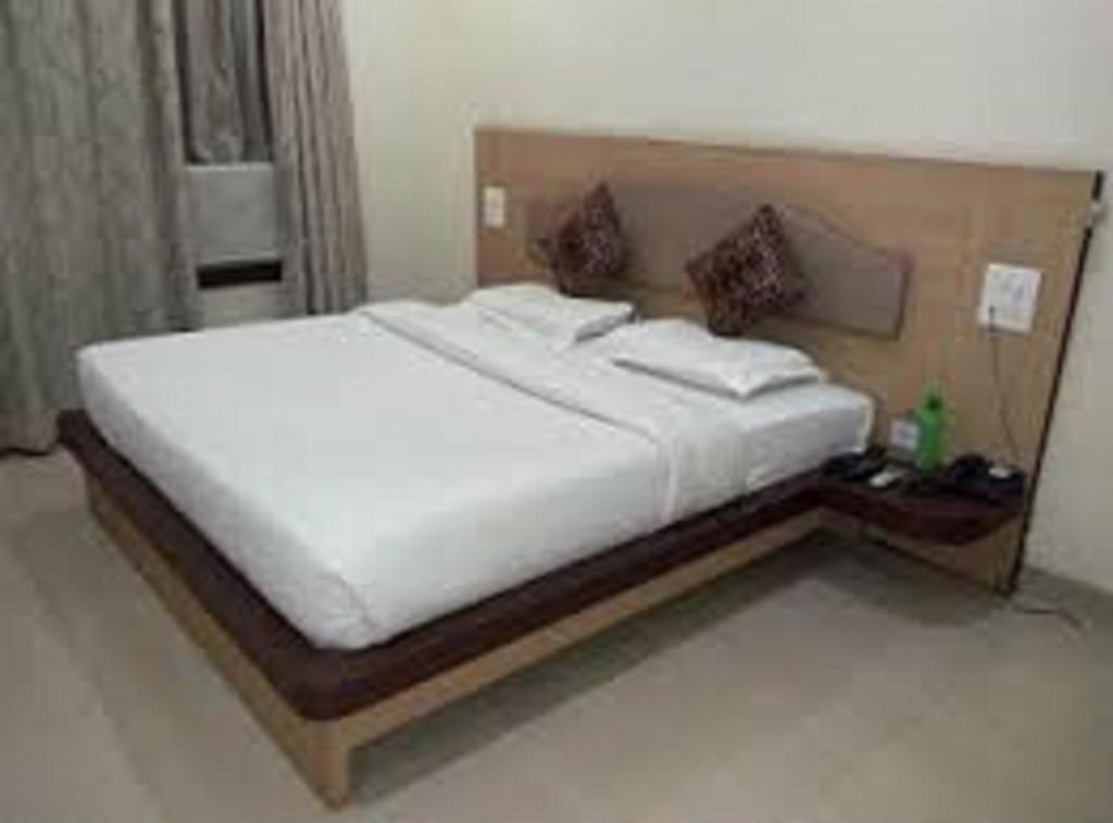 那格浦尔Hotel Sukhakarta, Nagpur的卧室配有一张白色大床