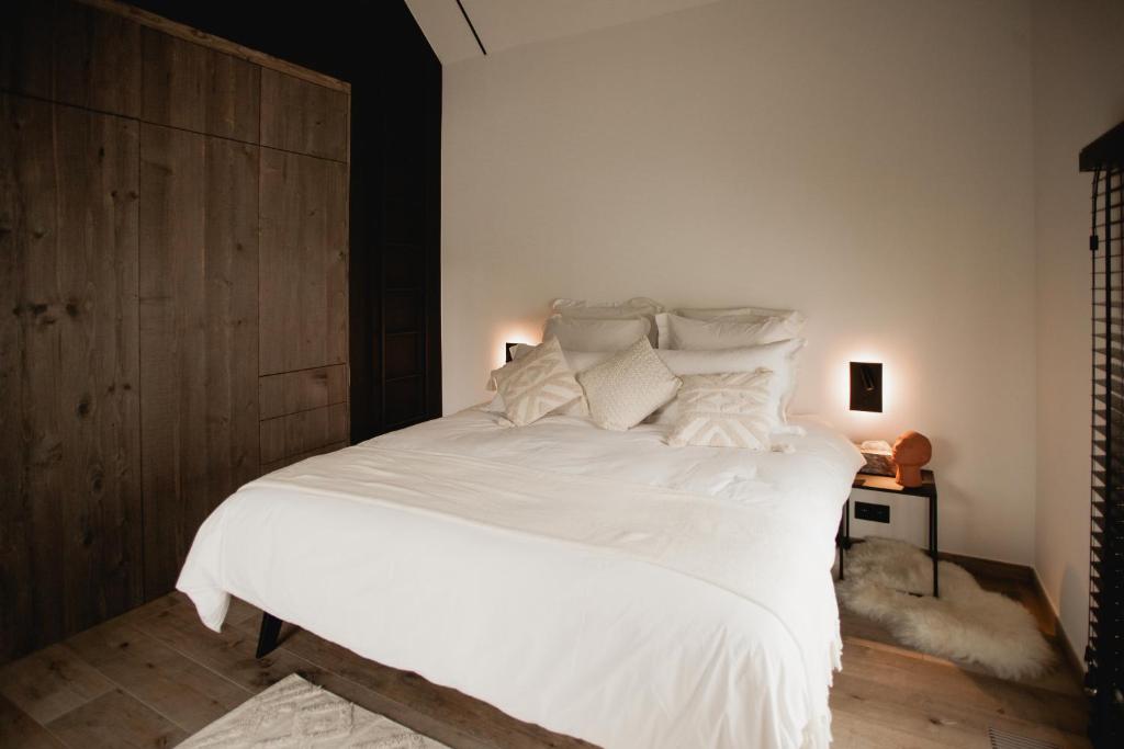 那慕尔Comme chez Lore - villa 2pers - piscine chauffée的卧室配有一张带白色床单和枕头的大床。