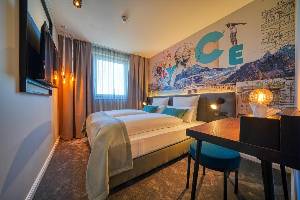 乌尔姆NYCE Hotel Ulm的配有一张床和一张书桌的酒店客房