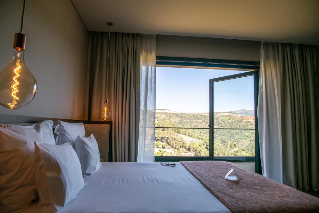 圣玛尔塔迪佩纳吉昂MW Douro Wine & Spa Experience Hotel Collection的一间卧室设有一张大床和一个大窗户