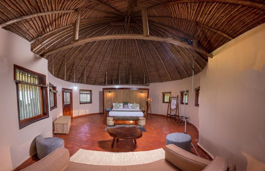 AruaTilenga Safari Lodge的大型客房设有床和大型天花板。