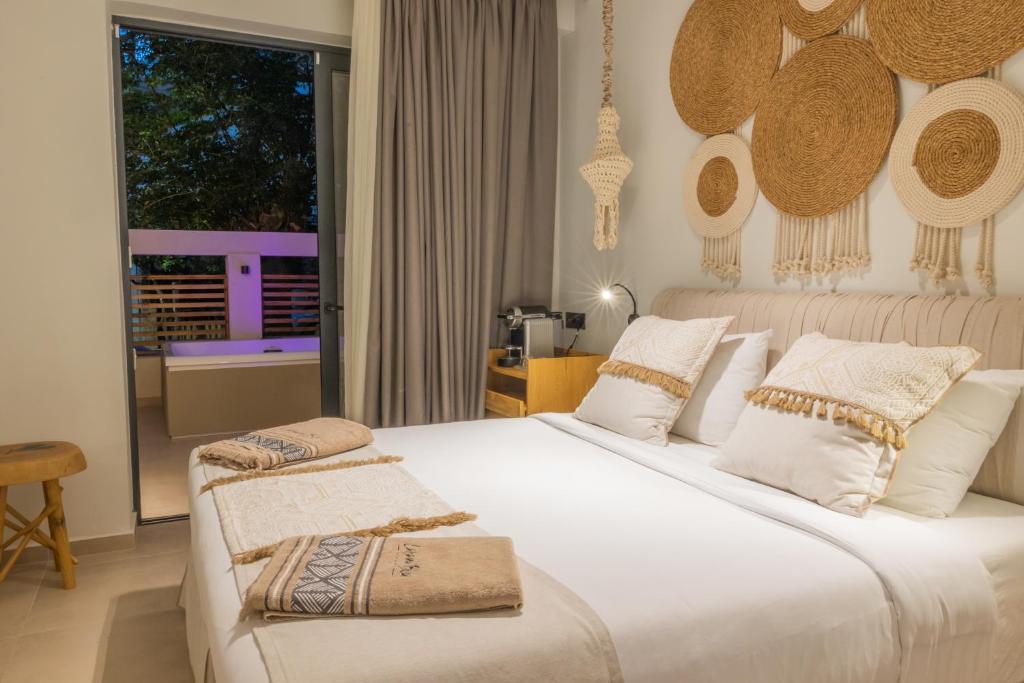 卡尔扎迈纳Cabana Blu Hotel & Suites的一间卧室设有两张床和窗户。