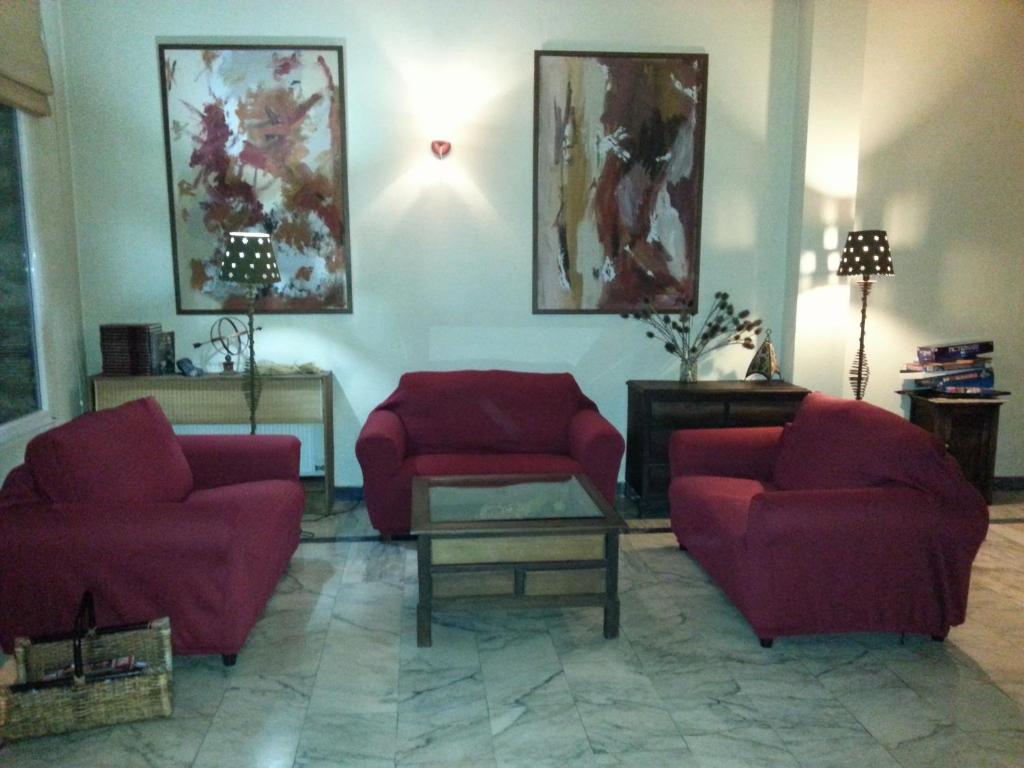 比利亚夫利诺拉布拉尼娜酒店的客厅配有2把红色椅子和桌子