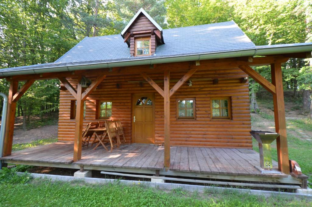 Jaroslavické PasekyMeadow Ranch Holiday Home的小木屋设有门廊和甲板上的桌子