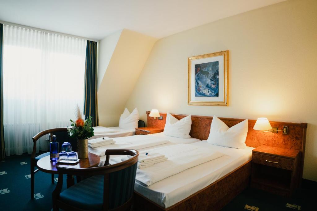 杜塞尔多夫老城圣乔治酒店的酒店客房设有一张大床和一张桌子。