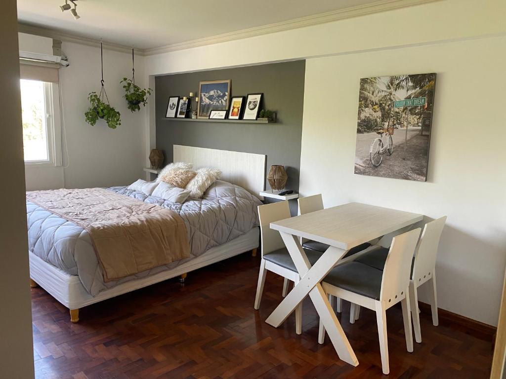 门多萨G3 Inn apartments的卧室配有一张床和一张桌子及椅子