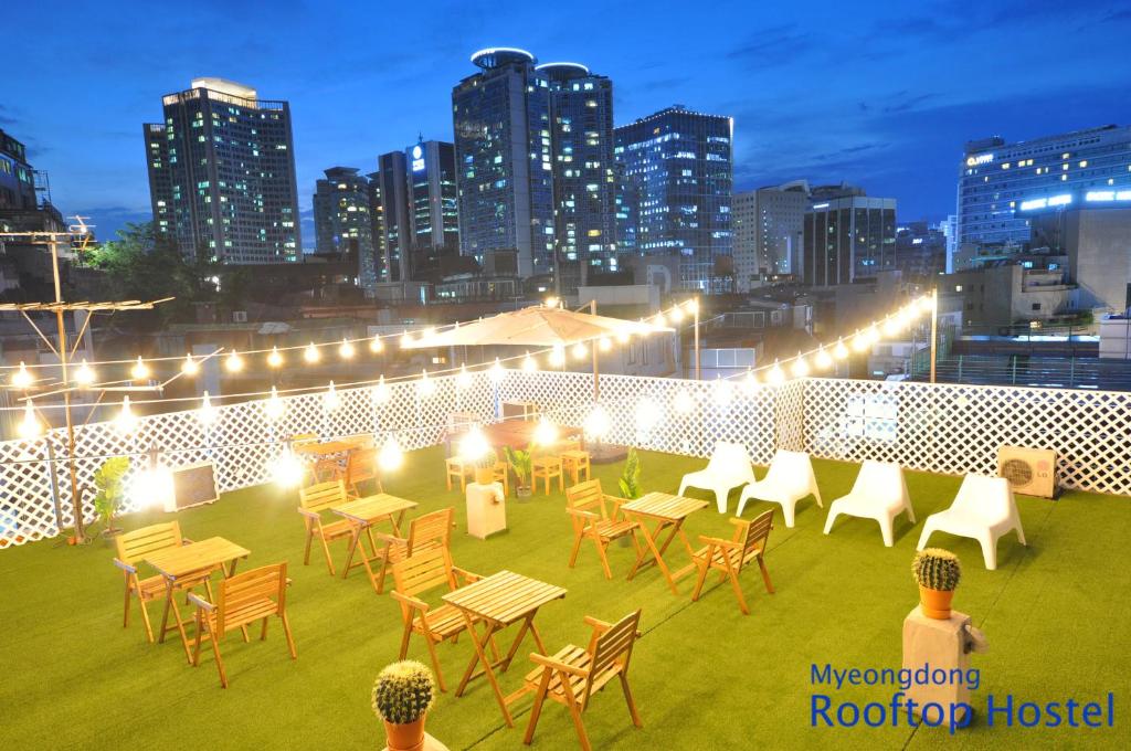 首尔OYO屋頂旅館的一个带桌椅的屋顶露台,享有城市天际线