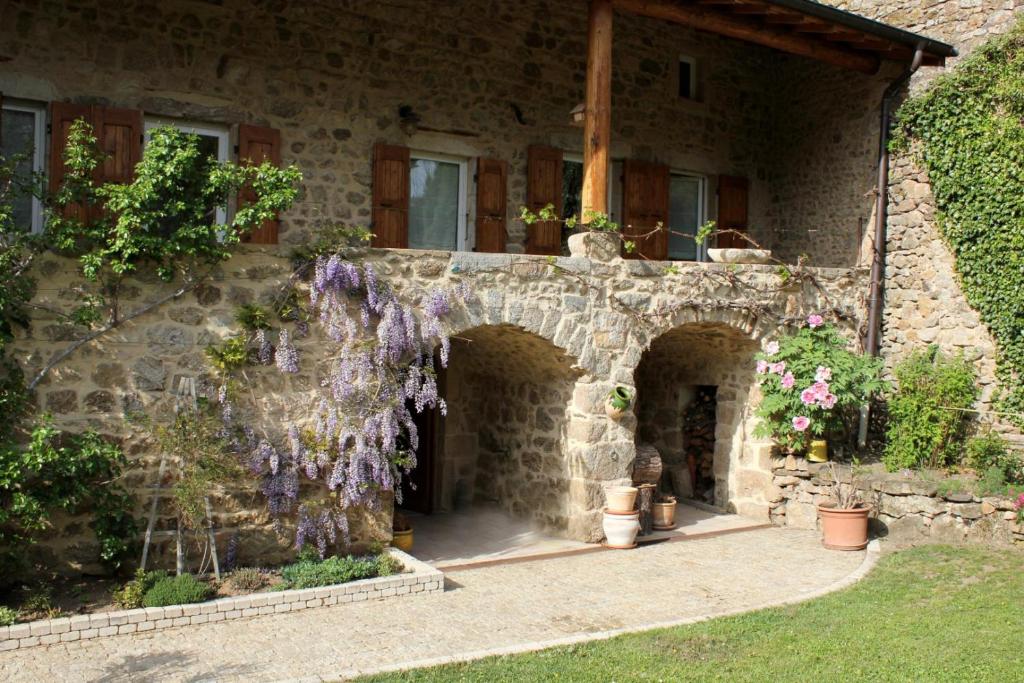 RoiseyLe clos du martouret的一座石头房子,旁边是紫色的花