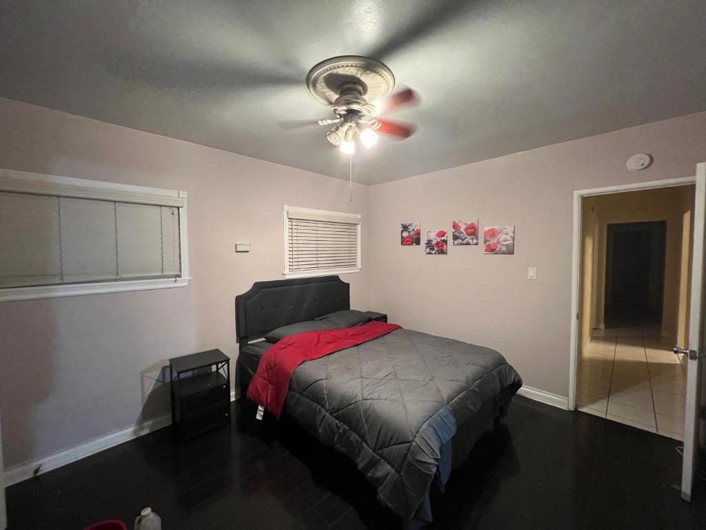 长滩Lucky House的一间卧室配有一张床和吊扇