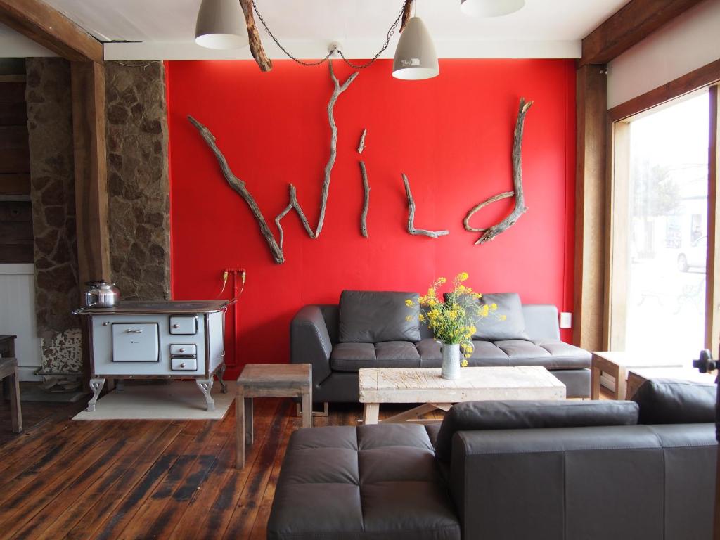 纳塔列斯港野生旅舍的客厅设有红色的墙壁和鹿角