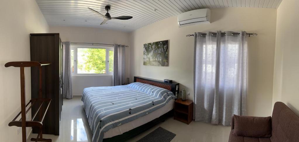 马埃岛Coco De Mer Villa的一间卧室配有一张床和吊扇