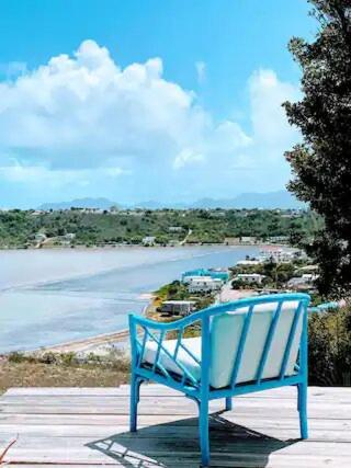 Sandy Ground VillageVilla Kaiae的蓝色长椅,坐在甲板上,眺望着大海