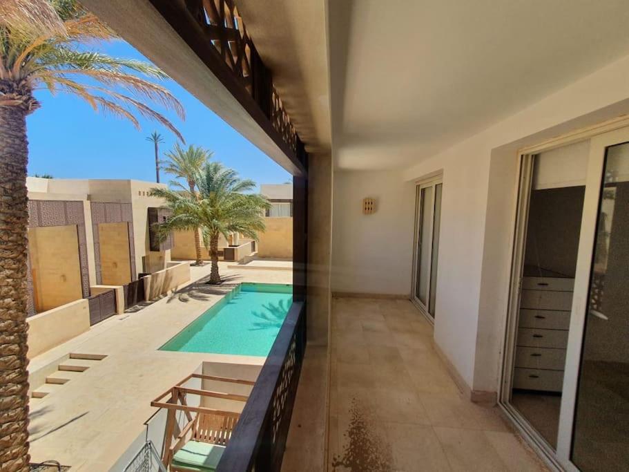 赫尔格达Nayah Stays, Beautiful 3-bedroom vacation home with lovely pool的一座带游泳池和棕榈树的房子