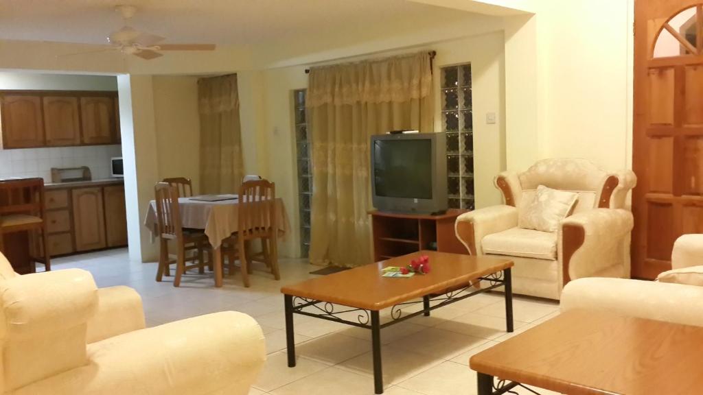 圣乔治杰瑞东公寓的客厅配有电视和桌子