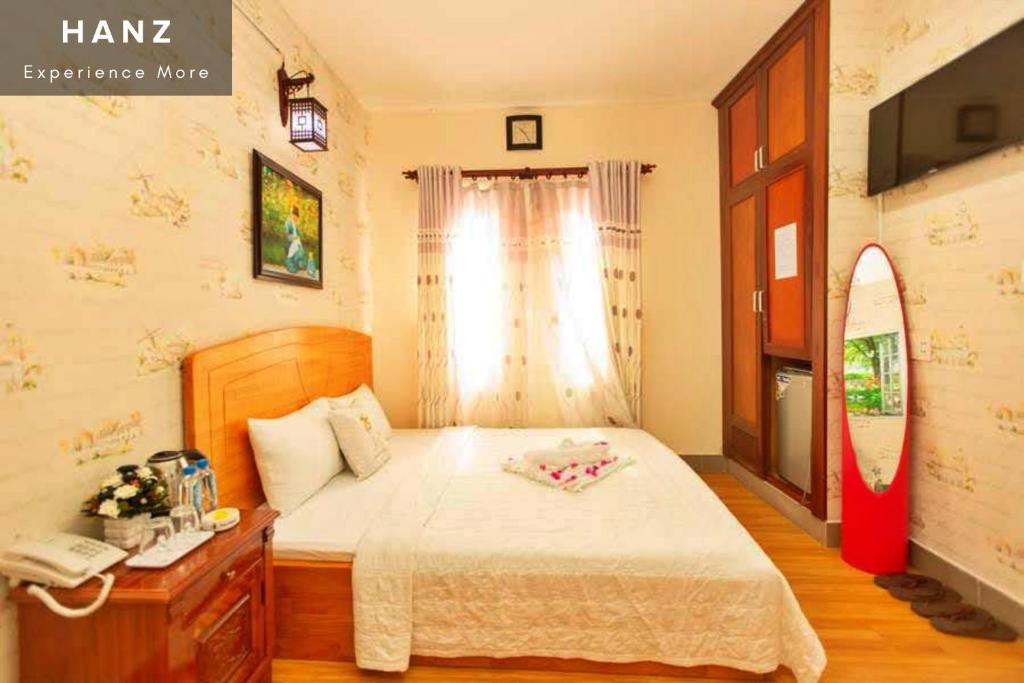 头顿HANZ Bao Khoi Hotel的一间卧室配有一张床和一部电话
