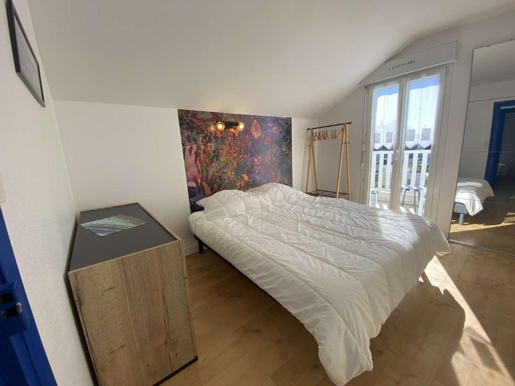 贝诺代Maison Bénodet, 3 pièces, 4 personnes - FR-1-481-125的卧室配有一张床,墙上挂有绘画作品