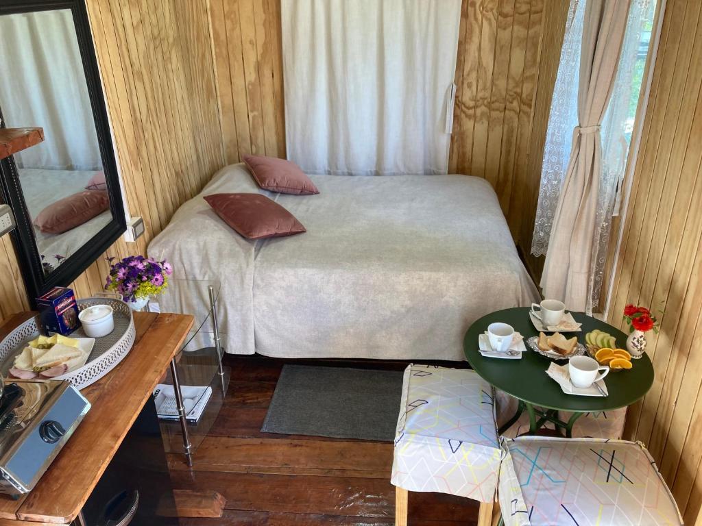 奇廉Cabaña Lemupewen Chillán的小房间设有一张床和一张桌子