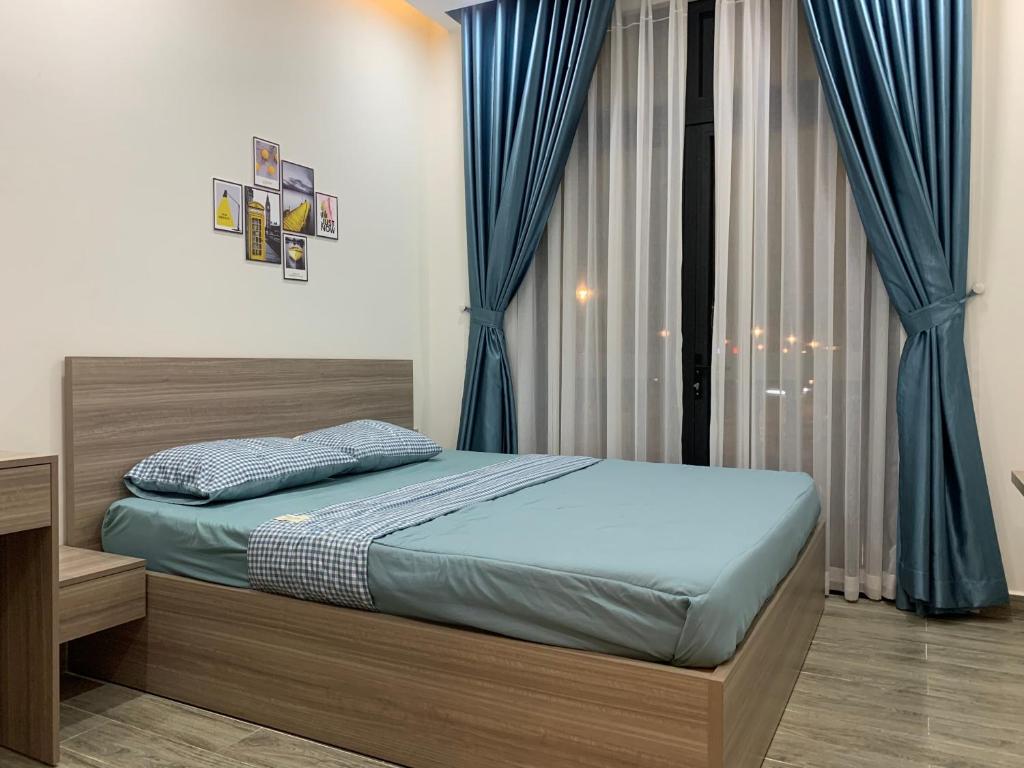 富国Liên’s Mini Hotel的一间卧室配有蓝色窗帘的床