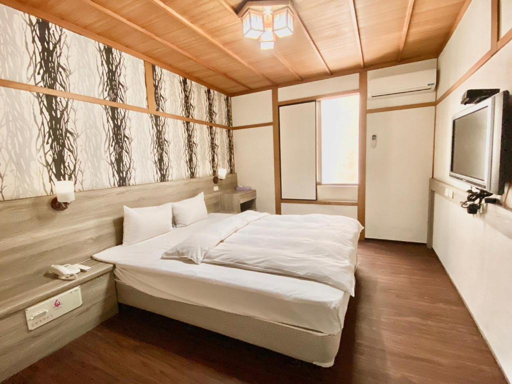 新竹WL HOTEL Hsinchu的一间卧室配有一张床和一台电视