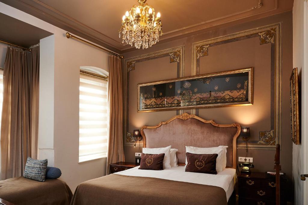 伊斯坦布尔Faik Pasha Hotels Special Category Beyoglu Istanbul的一间卧室配有两张床和吊灯。