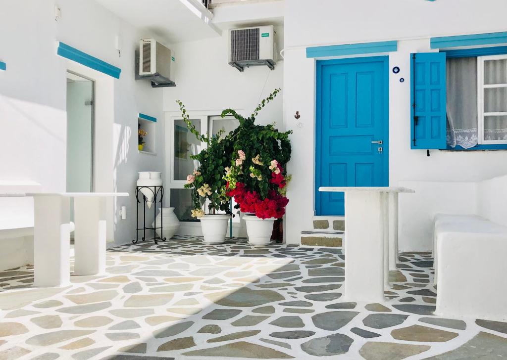 纳克索乔拉Taki's Guests的白色建筑中一扇蓝色门,上面有盆栽植物
