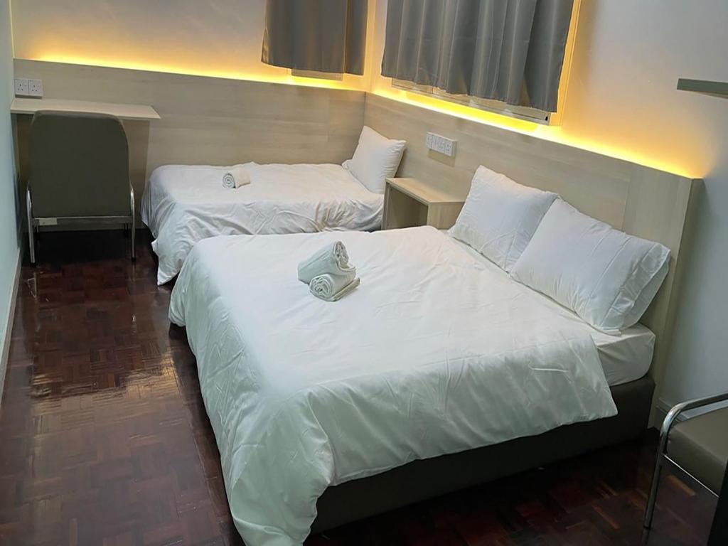山打根Sandakan Homestay SEMi D 3R2B For 10Pax的配有白色床单的酒店客房内的两张床