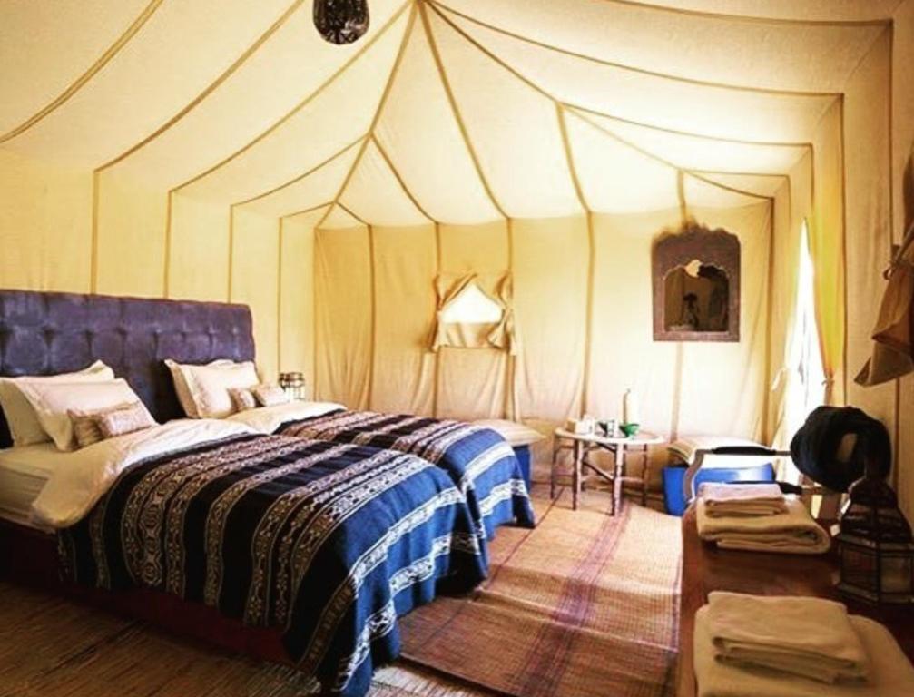 梅尔祖卡Sahara Luxury Tented Camp的帐篷内一间卧室,配有一张床