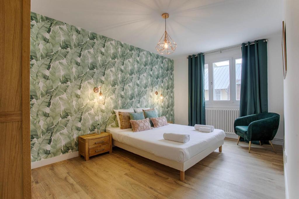 多维尔Les Caravelles - Trois Pièces - Deauville Centre的一间卧室设有一张床和绿色的墙壁