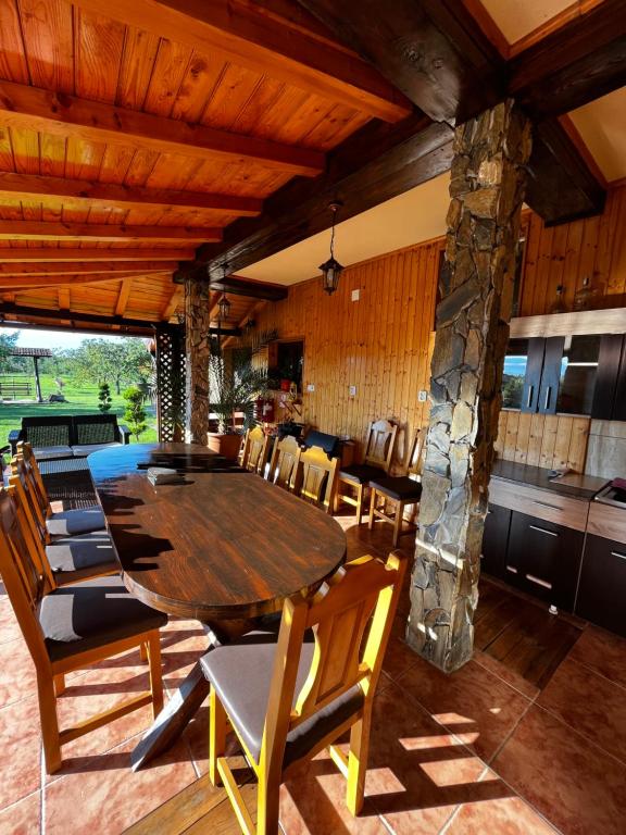 哈采格Vila SOFIA的一间带木桌和椅子的用餐室