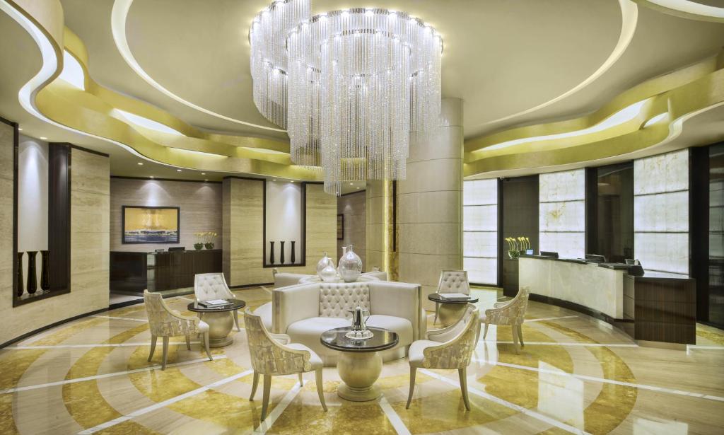 迪拜达玛克大厦庭院花园公寓式酒店的酒店大堂设有吊灯和椅子