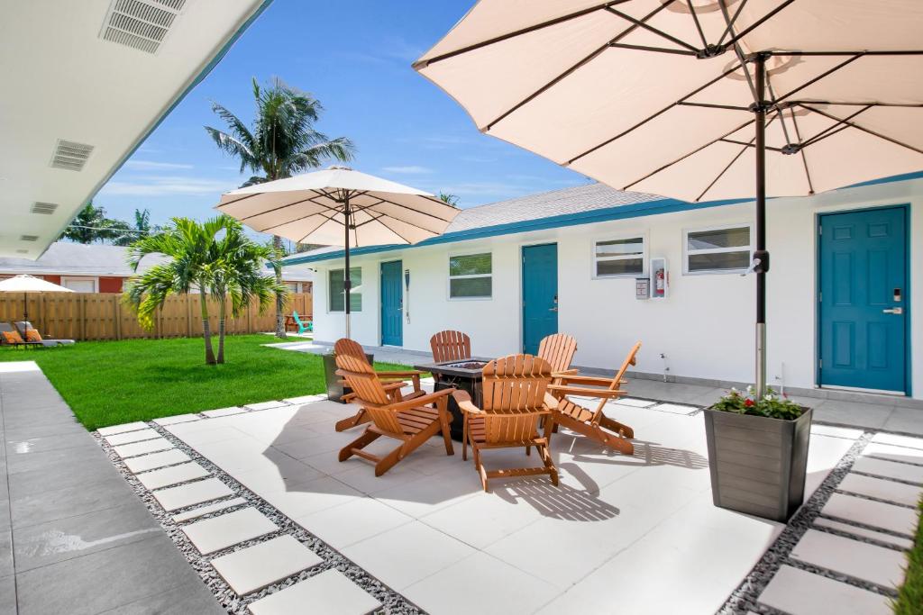劳德代尔堡LoKal Rental Tropical Florida destination的一个带桌椅和遮阳伞的庭院