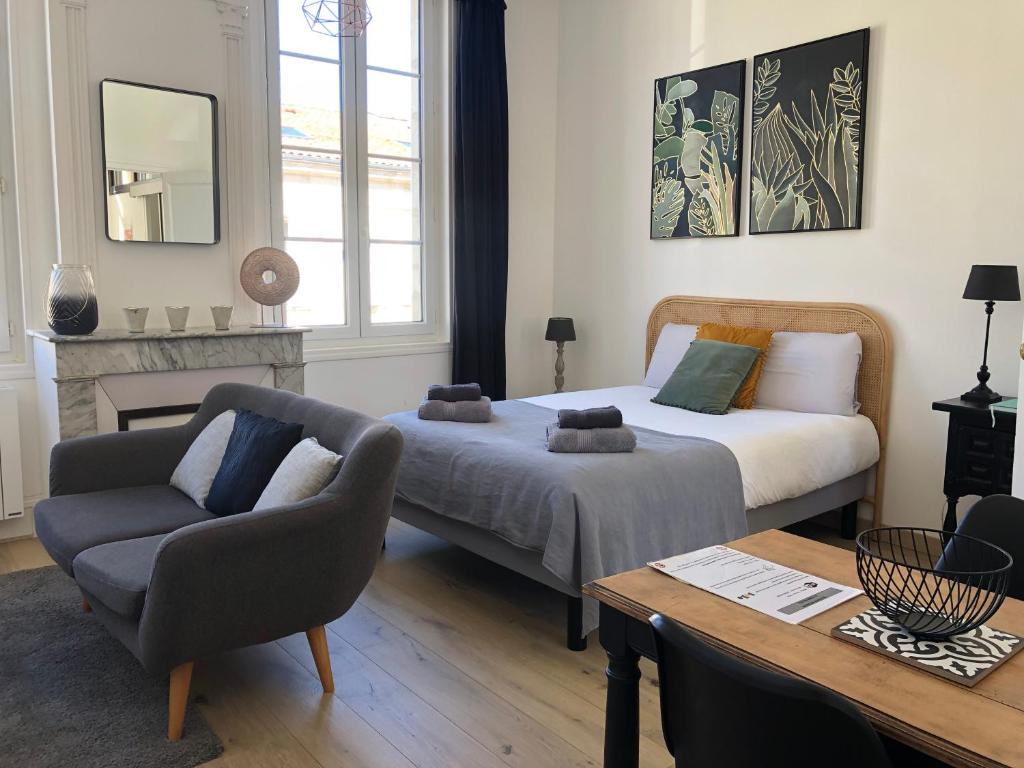 罗什福尔Le Studio de Meli, 3 étoiles, 30m2, raffiné, élégant et bien situé的客房设有两张床、一张沙发和一张桌子。