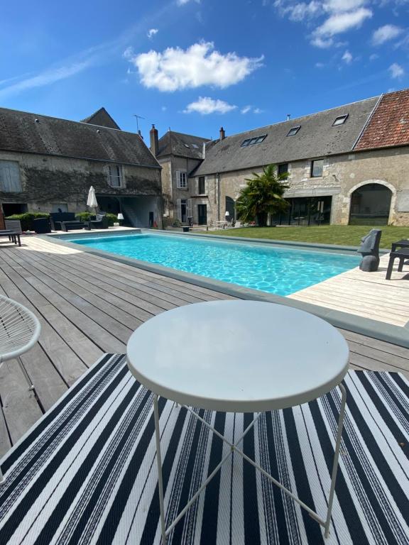 圣萨蒂尔VILLA MARLISE Chambre Hôtes的一个带白色桌子和游泳池的庭院