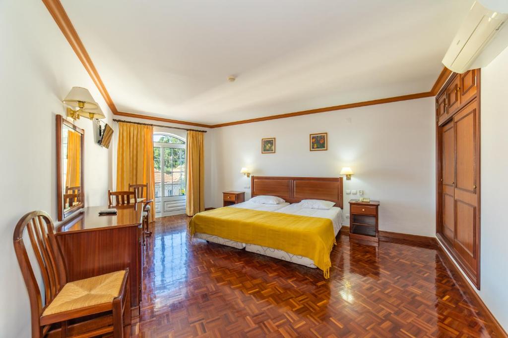 卢索中央酒店 的一间卧室配有一张黄色床罩的床