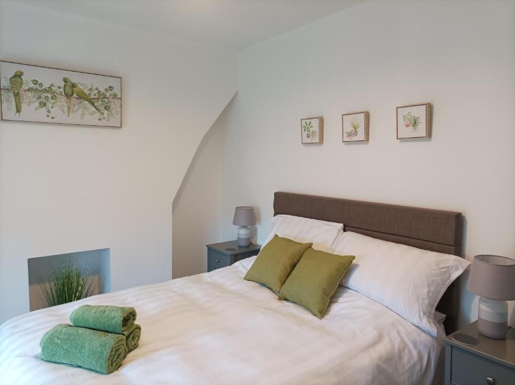 利物浦Victorian Renovation Room 5的卧室配有白色床和2个绿色枕头