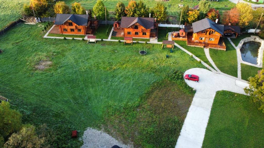 莱斯诺夫La Cabane Râșnov的绿色田野上房屋的空中景观