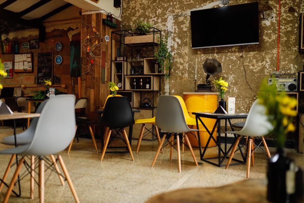 麦德林Panela Coffee Hostel的一间设有椅子和墙上电视的房间