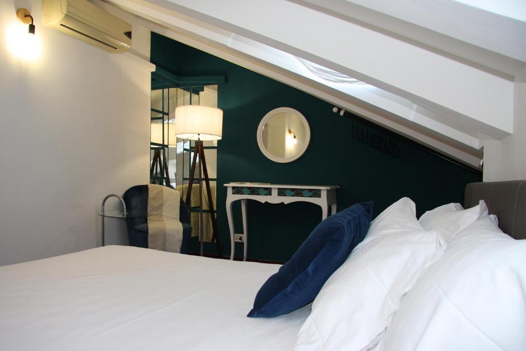 米兰Mercanti Attic Version的卧室配有白色的床和绿色的墙壁