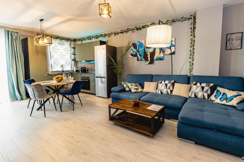 锡比乌Alice apartment的客厅配有蓝色的沙发和桌子