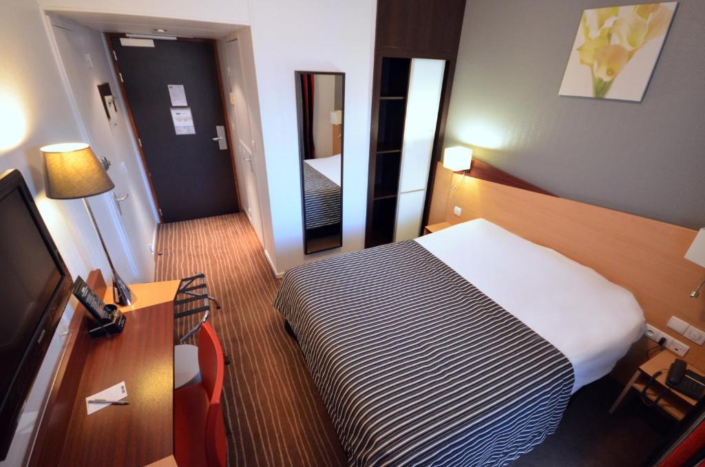 第戎基里亚德迪容车站酒店的酒店客房配有一张床、一张书桌和一台电视。