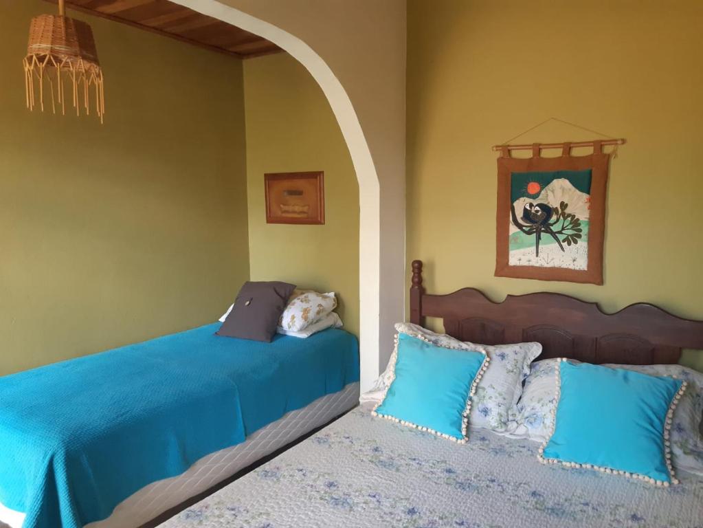 卡瓦坎特Pousada Manacás的一间卧室配有两张蓝色床单