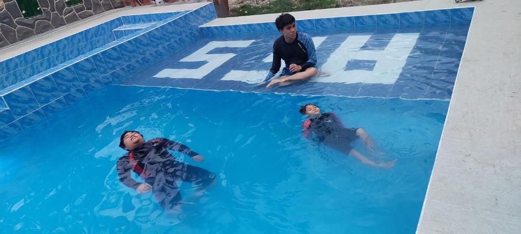 卡加盐德奥罗AFS Suites Barra, Opol的两个男人在游泳池里