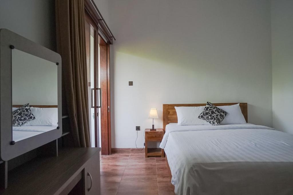 沙努尔Taman Bali Homestay的一间卧室配有一张床和一台平面电视