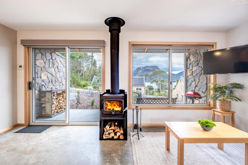 科尔斯湾Freycinet Stone Studio 7 - Quartz的客厅设有燃木火炉和窗户