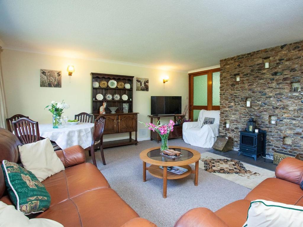 SouthleighPurlbridge Bungalow的带沙发和石制壁炉的客厅