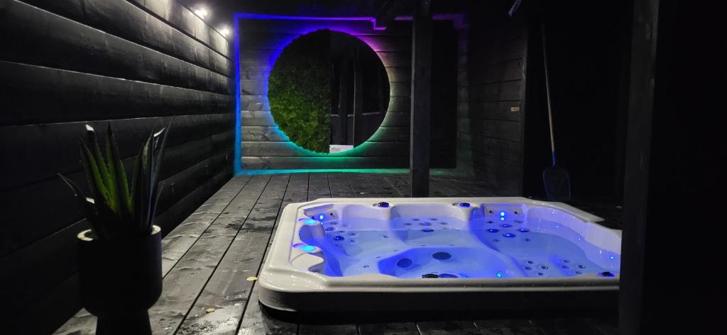 伊斯泰布纳Fabryka Snów loft w sercu Beskidów的浴室配有蓝色浴缸和紫色灯