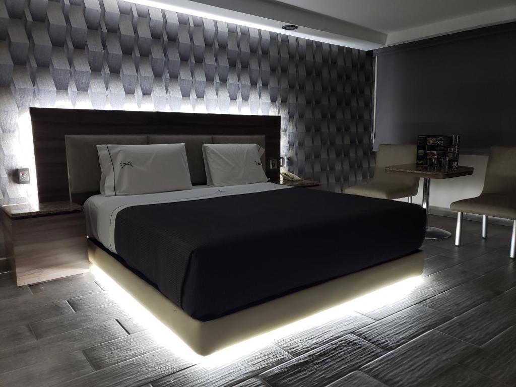 墨西哥城Motel Nuevo Tijuana的一间卧室配有一张黑色大床和LED照明