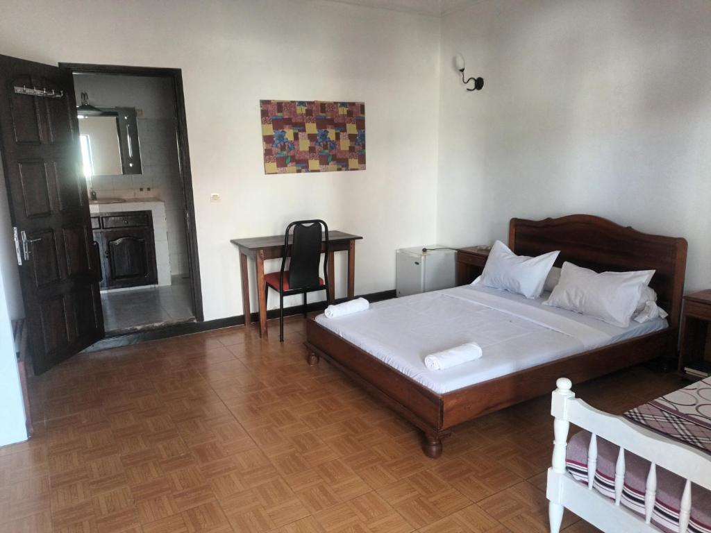 迭戈苏瓦雷斯LOTUS HOTEL的一间卧室配有一张床和一张桌子及椅子